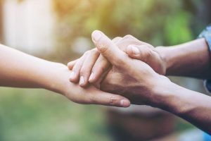 Two young people holding hands with blur background