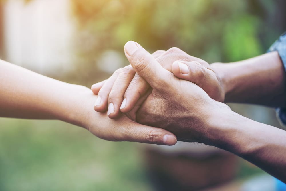 Two young people holding hands with blur background
